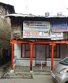 A run down a two-story building with several signs related to AIDS prevention
