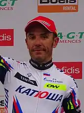 A photograph of Joaquim Rodríguez raising his arm to acknowledge applause