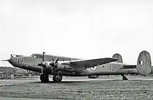 A black and white image of a four-propellered aircraft