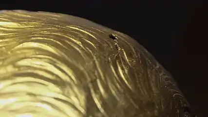 Hole and crack on a gold surface.