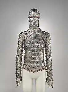 A garment made of plates of metal joined together, adorned with small red gemstones. It covers the entire torso, arms, and face, except for the eyes.