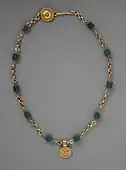 Necklace with a medallion depicting a goddess; 30–300 AD; green glass (the green beads) and gold; length: 43.82 centimetres (17.25&nbsp;in); Los Angeles County Museum of Art