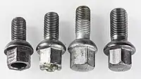 Four lug bolts, from left: Three M12×1.5&nbsp;mm bolts with different length and one M14×1.5&nbsp;mm bolt