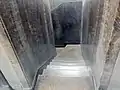 Stairs behind elevator to basement.