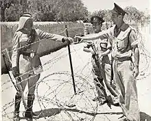 Israeli policemen meet a Jordanian Legionnaire near the Mandelbaum Gate (c. 1950)