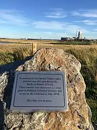 A photograph of a plaque at Dunbar, commemorating the Scottish prisoners who were buried in a mass grave at Durham