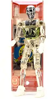 A photo of a vintage Microman M101 (George) 3.75-inch-tall (9.5 cm) action figure with capsule in the background.