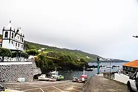 The fishing port and coastal perspective of Calheta de Nesquim, with the parish church dedicated to São Sebastião