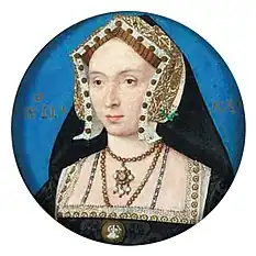 Face of a young woman wearing rich black clothing, cap, and veil with many jewels and golden lining.