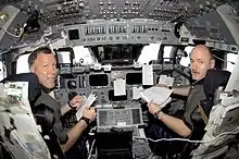 Dominic Pudwill Gorie, STS-108 commander, and pilot Mark Kelly are in their respective stations during rendezvous operations with the ISS. Pudwill Gorie brought Endeavour to a gentle linkup with the ISS as the two craft sailed over England.