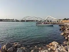 The Maqta' Bridge (Arabic: جِسْر ٱلْمَقْطَع, romanized: Jisr Al-Maqṭaʿ; front) and Sheikh Zayed Bridge (Arabic: جِسْر ٱلشَّيْخ زَايِد, romanized: Jisr Ash-Shaykh Zāyid; back) at Al-Maqṭaʿ (Arabic: ٱلْمَقْطَع), which connects the island of Abu Dhabi to the mainland