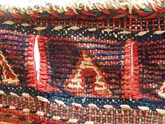 Detail of decorative border, with slits for rope to close and secure bag