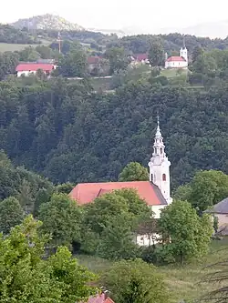 Our Lady Comforter of the Afflicted Church in Stopiče.In the background, Gornja Težka Voda.