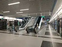 Island platform with escalators leading upwards to the station exit