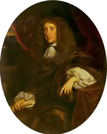 Oil painting of Thomas Staveley. Staveley is painted from the knee up, in an oval frame. He sits to the left, placing his left elbow on a velvet-covered table, and faces towards the viewer. He wears a cloak, with a lace cravat, and large chestnut wig, clutching a scroll in his right hand.