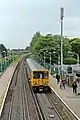 A Merseyrail class 507 waits at the station, viewed from the footbridge.