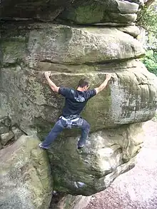 A rock climber scaling a sandstone crag.